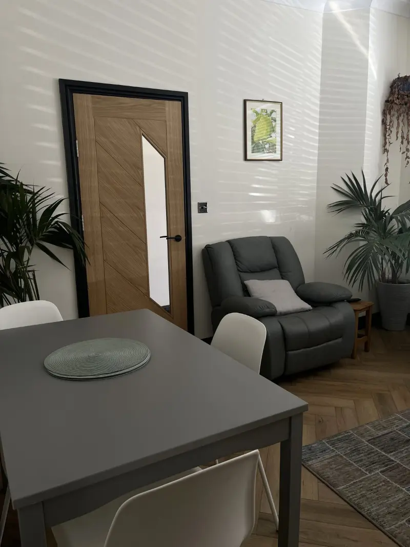 Dining area with oak door, armchair and plants