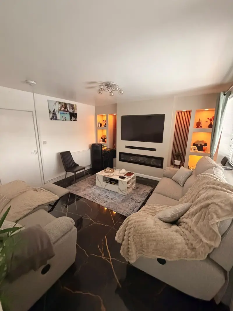 A warm, freshly cleaned living room with cream sofas and soft lighting