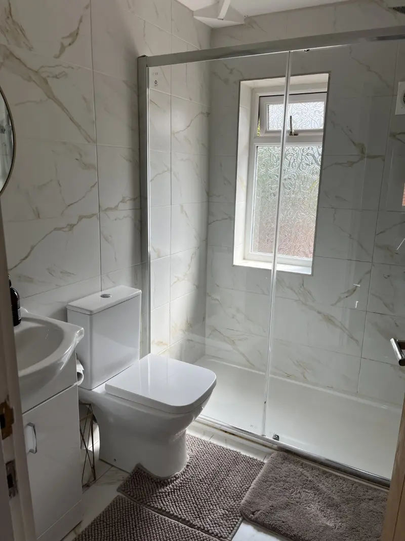 Marble-tiled shower room with spotless glass screen